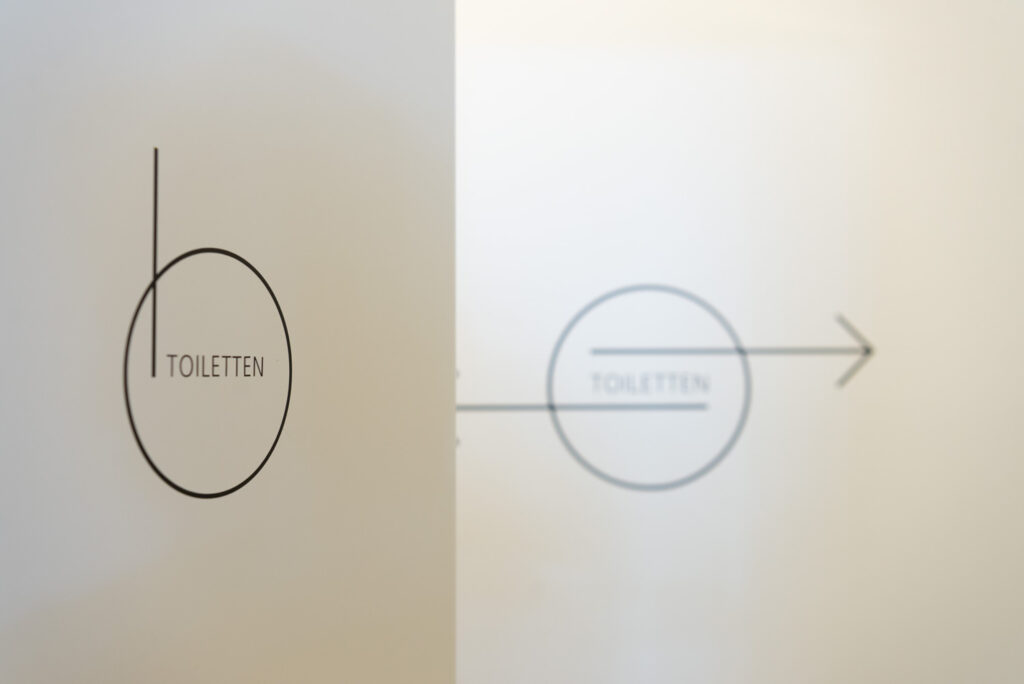 Ungewöhnliche minimalistische Grafik für die Wegeleitung zu den Toiletten