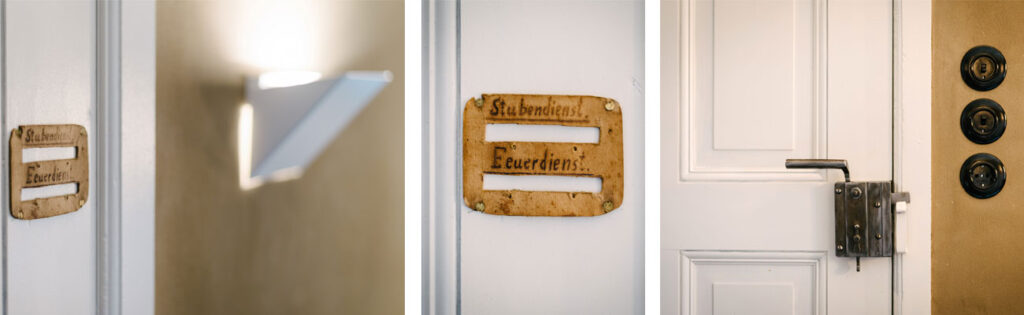 Dreierbild mit Details aus einem Bad in einem Bauernhaus mit Lehmputz. Man sieht eine historische weiß lackierte Kassettentür mit Kastenschloss, runde Bakelit-Lichtschalter und ein altes Pappschild mit der Aufschrift: "Feuerdienst" und "Stubendienst".