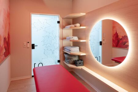 roter Behandlungsraum nach Umbau mit Spiegel und Tür in der Physiotherapie-Praxis