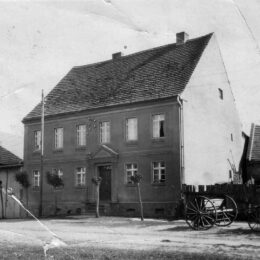 Historisches Schwarzweiß-Foto eines Bauernhauses mit Satteldach und zwei Etagen. Führt als Projektkachel zur Webseiten über Bauernhaus sanieren.