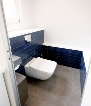 WC mit Fliesen in CI-Farbe, geplant von raumdeuter, Innenarchitekt in Berlin