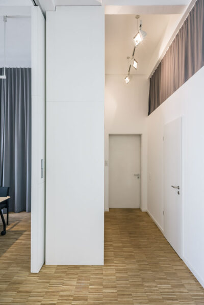 Blick in den Flur mit Vorhängen vor den Stauräumen, geplant von raumdeuter, Ihrem Innenarchitekt in Berlin