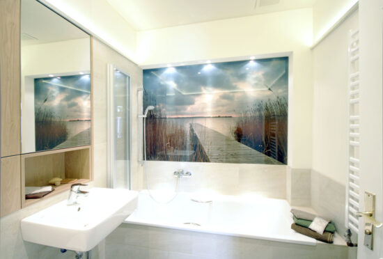 Blick in kleines Bad mit Wanne und Fotomotiv, geplant von raumdeuter, Innenarchitekt in Berlin
